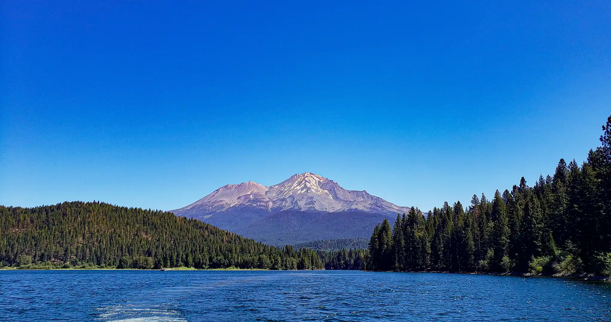 A lake with a snow-covered mountain in the background.